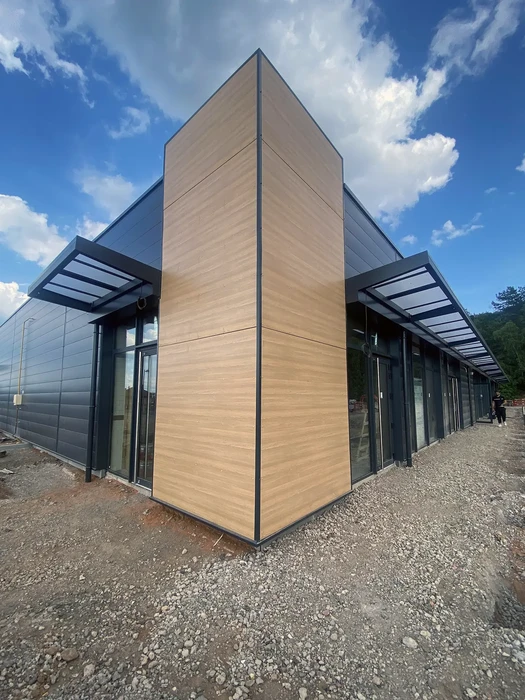 Bâtiment moderne à architecture contemporaine avec façade mixte en bardage bois naturel et panneaux métalliques anthracite