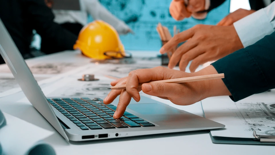 Réunion d'équipe dans salle de conférence moderne avec quatre professionnels assis autour d'une table en bois