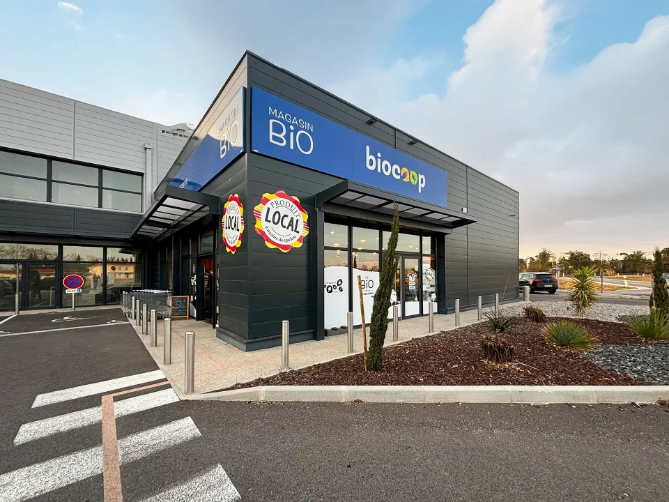 Devanture de commerce avec panneau "Come in, we're OPEN" suspendu à une chaîne