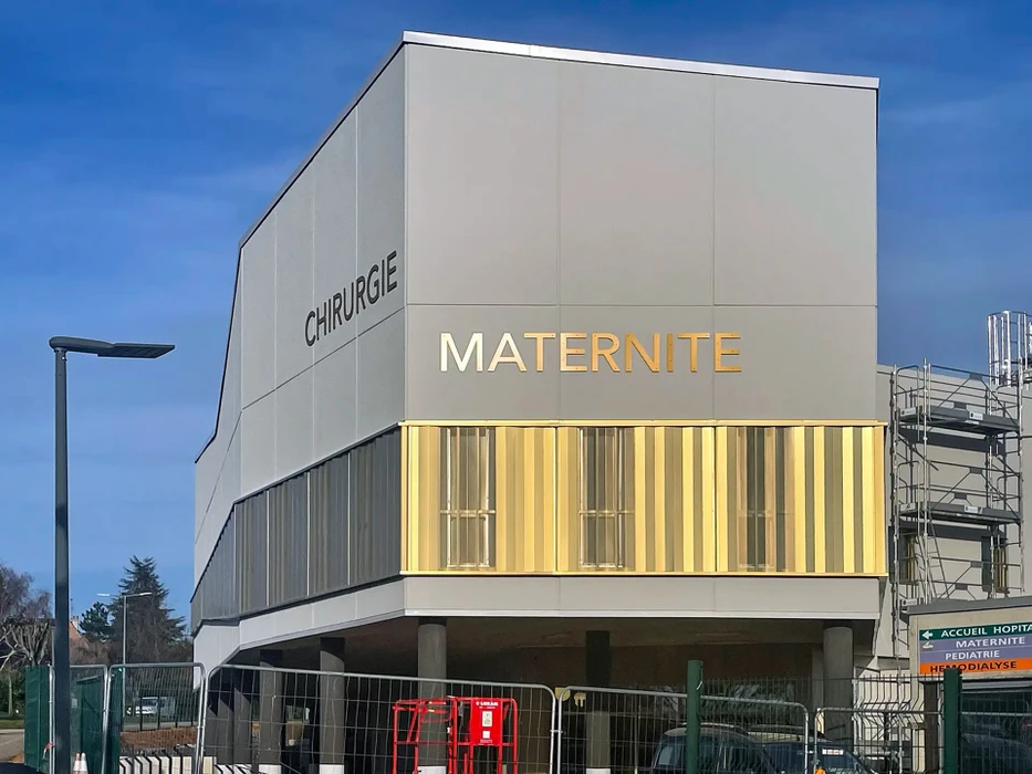 Bâtiment industriel moderne en construction avec bardage métallique horizontal gris anthracite