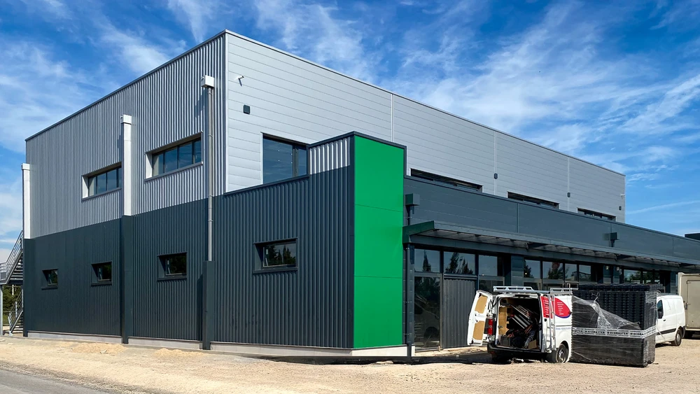 Bâtiment industriel moderne en construction sur terrain en terre battue